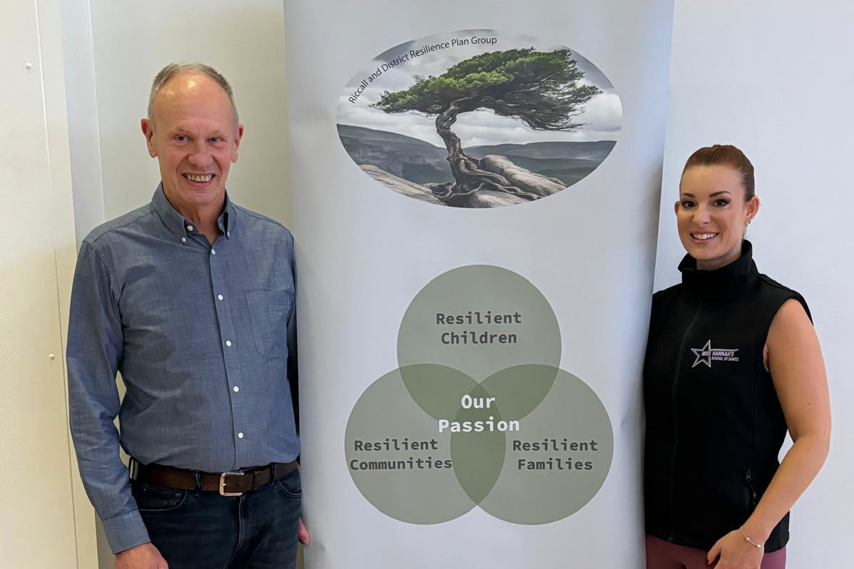 2 people standing next to resilience group banner